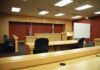 Judge Sentences Truck Driver in Fiery California Crash Interior view of an empty courtroom with wooden furniture and American flags