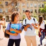 Students walking on campus with books and backpacks