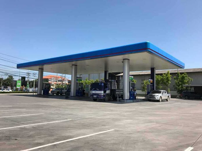 shutterstock_1092730340-1 Gas station canopy with fuel pumps and vehicles on a clear day