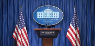 White House press podium with microphones and two American flags