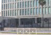 Embassy building behind tall black security fence