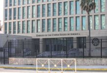 Embassy building behind tall black security fence