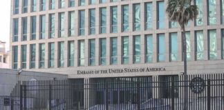 Embassy building behind tall black security fence