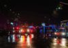 Man Hospitalized After NYC Lobby Fire Nighttime police scene with flashing lights on a wet city street