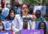 Veteran Suicide Prevention Campaign Hits 500M Views Woman speaking at outdoor rally behind microphones