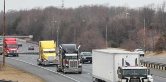 Convoy of semi trucks driving on a multi-lane highway