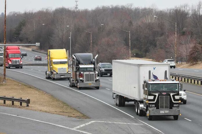shutterstock_2132851557 Convoy of semi trucks driving on a multi-lane highway