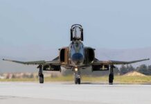 Military jet taxiing on runway with open canopy