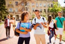 Students walking on campus with books and backpacks