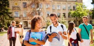 Students walking on campus with books and backpacks