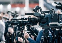 City Hall Orders Spark Political Firestorm Broadcast cameras on tripods at a press event