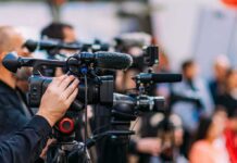 Convicted Deputy Dies Behind Bars Video cameras on tripods at a media event