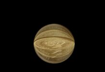 Gold coin distorted through a crystal ball on black background