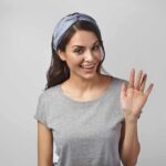 Hollywood Stunner: Beloved Actress Dies at 36 woman smiling and waving in a gray t-shirt