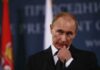 Putin Ally Bankrolls: Russian-Funded Bahamas Bash man in suit at podium touching his face