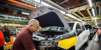 factory worker assembling a pickup truck on an automotive production line