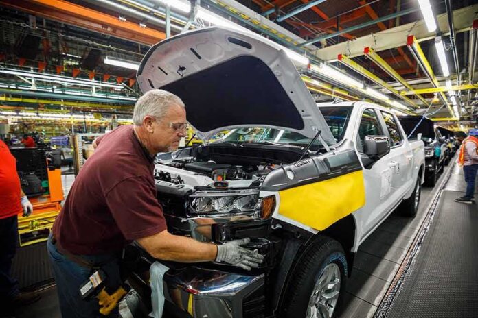 shutterstock_1153492843 factory worker assembling a pickup truck on an automotive production line