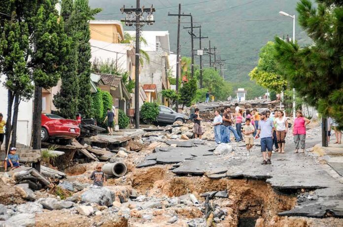 shutterstock_1165722466 Residents walk along a heavily damaged street after a disaster