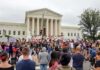 David Givens at a large protest outside a neoclassical courthouse