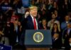 man speaking at a podium during a rally