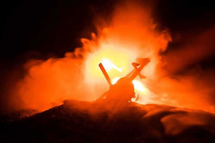 shutterstock_1220566891-1 Toy helicopter silhouette against fiery explosion at night