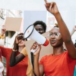 The Left Is More Divided Than Most Americans Realize Protester with megaphone leading a crowd