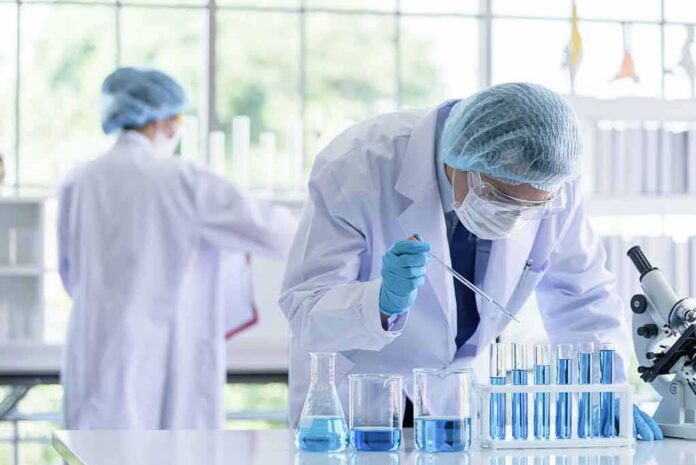 shutterstock_1365781304 Scientist pipetting blue liquid into test tubes in a laboratory