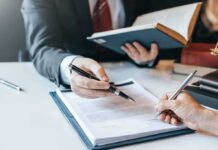 Hands signing a legal document at a desk