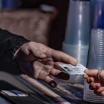 A Restaurant Promotion Is Fueling America’s Latest Election Security Clash Hands exchanging an ID card at a counter