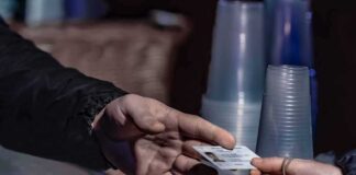 Hands exchanging an ID card at a counter