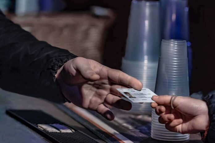 shutterstock_1498254014 Hands exchanging an ID card at a counter