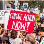 America at 250: Celebration or Critique? Crowd at climate protest holding signs