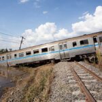 Deadly Impact: UK Train Crash Near Bedford An overturned train on a railway track surrounded by vegetation