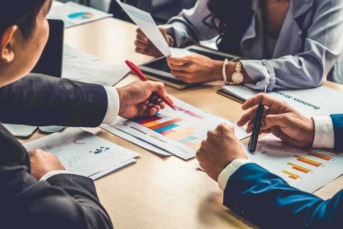 shutterstock_1767864710 business team reviewing charts at a meeting table