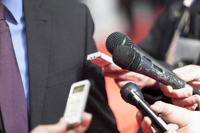 shutterstock_182152229 microphones held toward a person in a suit