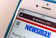 Housing Costs Spark Immigration Debate Smartphone displaying Newsmax website