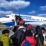 Passengers boarding a commercial airplane via mobile stairs