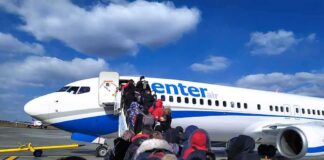 Passengers boarding a commercial airplane via mobile stairs