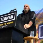 Democrat Shocks GOP Crowd With Trump Praise Speaker at outdoor rally standing at podium with microphone