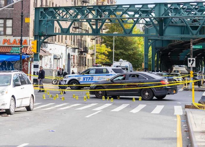 shutterstock_2214792785-1 Police cars block a city intersection with yellow crime scene tape