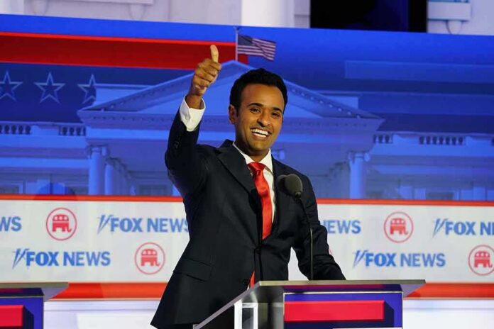 smiling man in suit at debate podium giving thumbs up