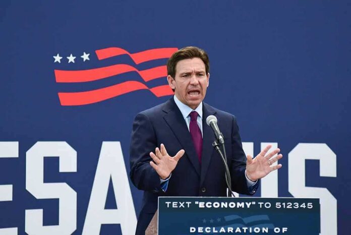 shutterstock_2352132685 Ron DeSantis speaking at a podium with a microphone