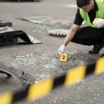 Another Epstein Associate Dies Forensic investigator marking evidence at crash scene