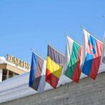 Row of national flags on a snowy building facade