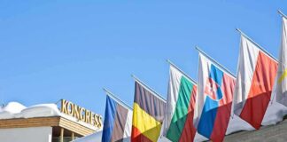 Row of national flags on a snowy building facade