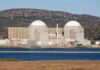 China’s Reactor: A Nuclear Buildout Surges Nuclear power plant with domed structures beside a water body and mountains in the background