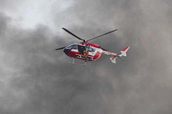 shutterstock_554743687 Rescue helicopter hovers amid thick smoke