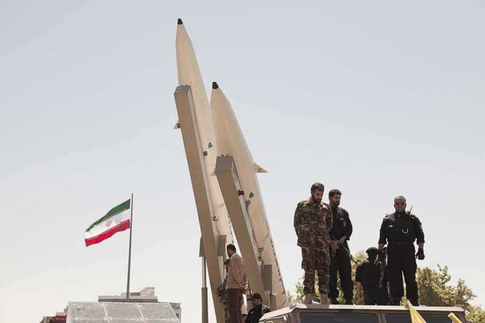 shutterstock_681421708-1 Soldiers stand beside large missiles at an outdoor display