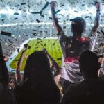 Iran Strike Pause Fuels Wall Street Rally Fans celebrate in a packed stadium with confetti falling