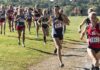 women cross-country runners racing on a grassy trail